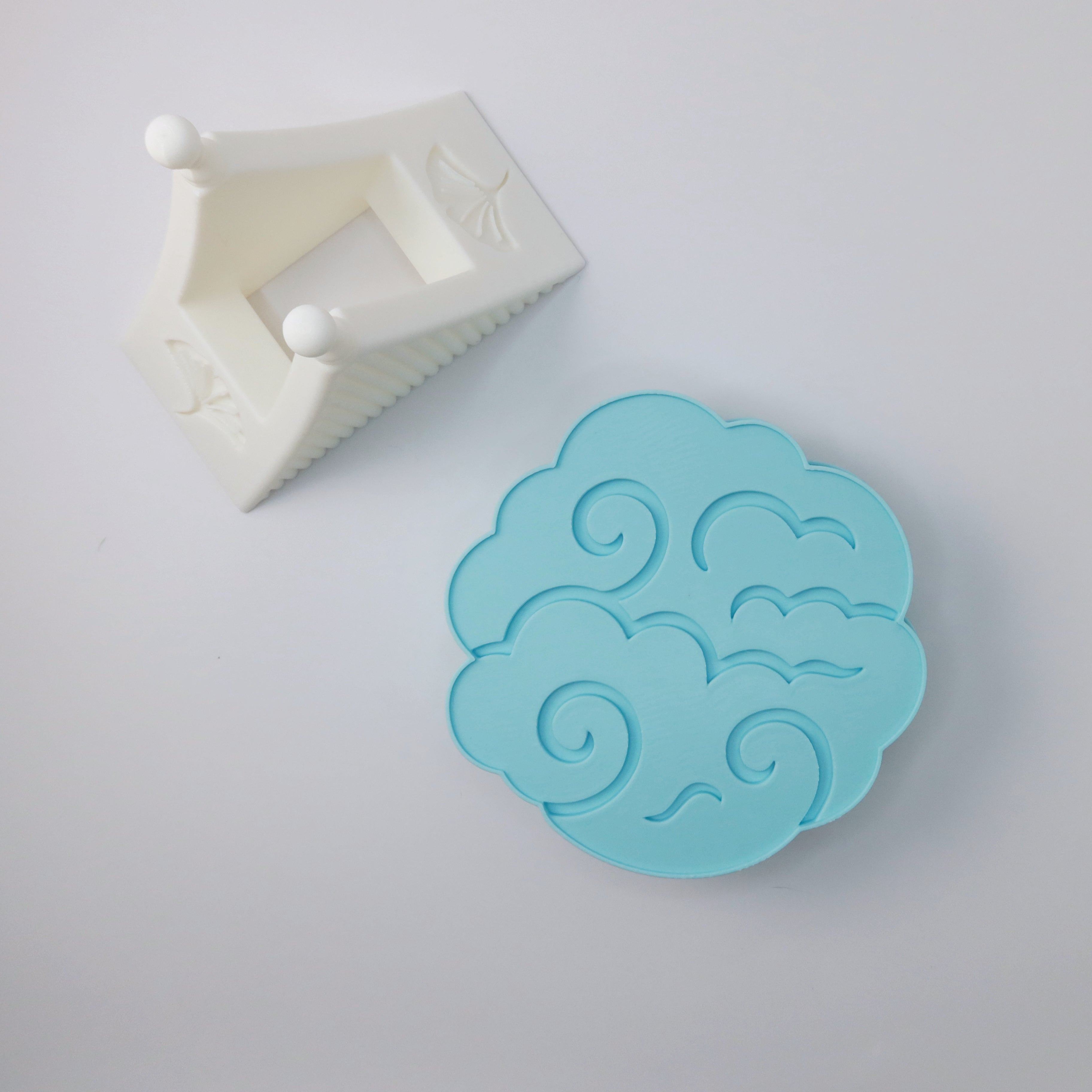 Blue cloud-shaped coasters on a light gray background