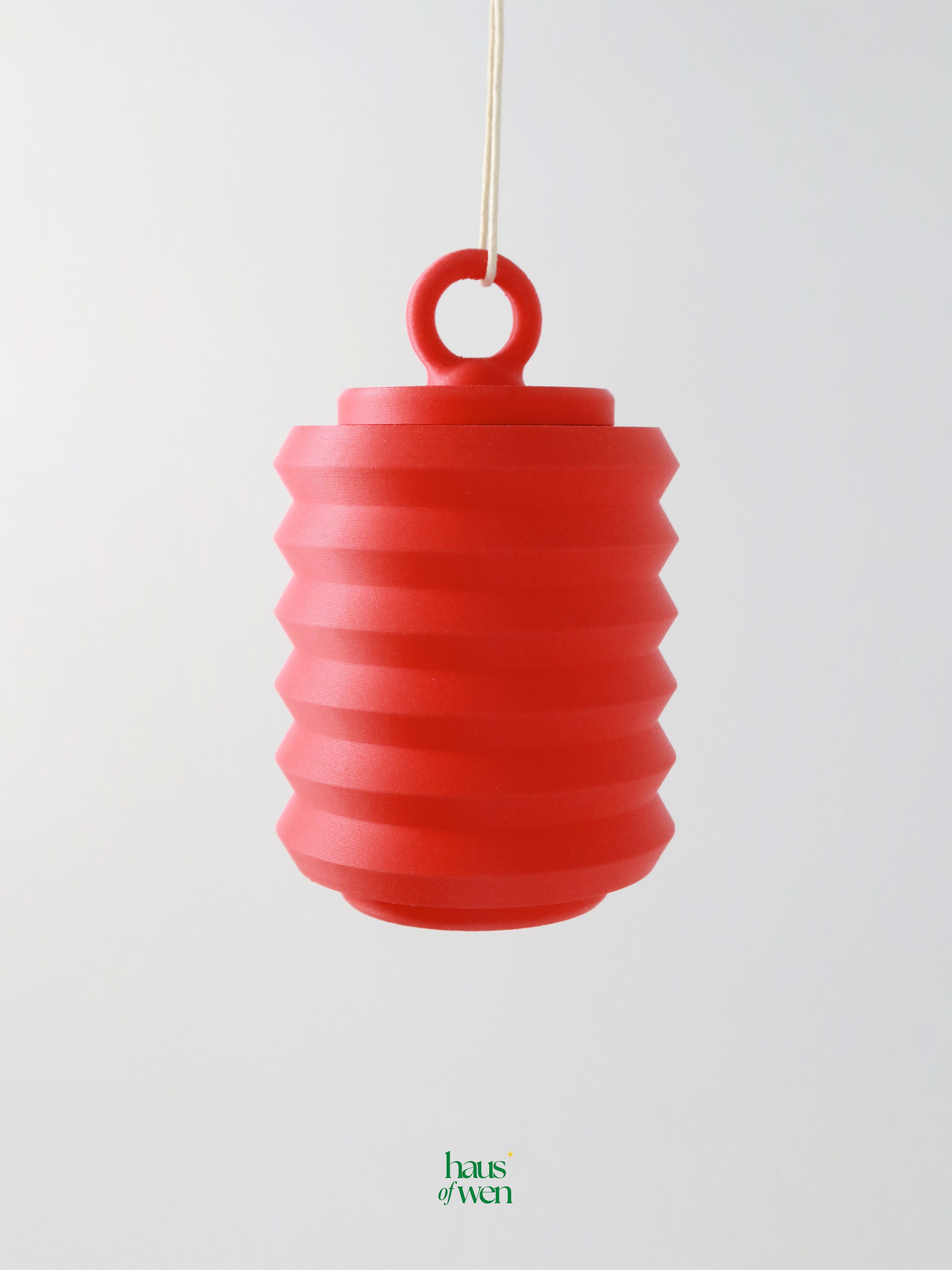 Red lantern ornament hanging against a light gray background with "haus of wen" branding