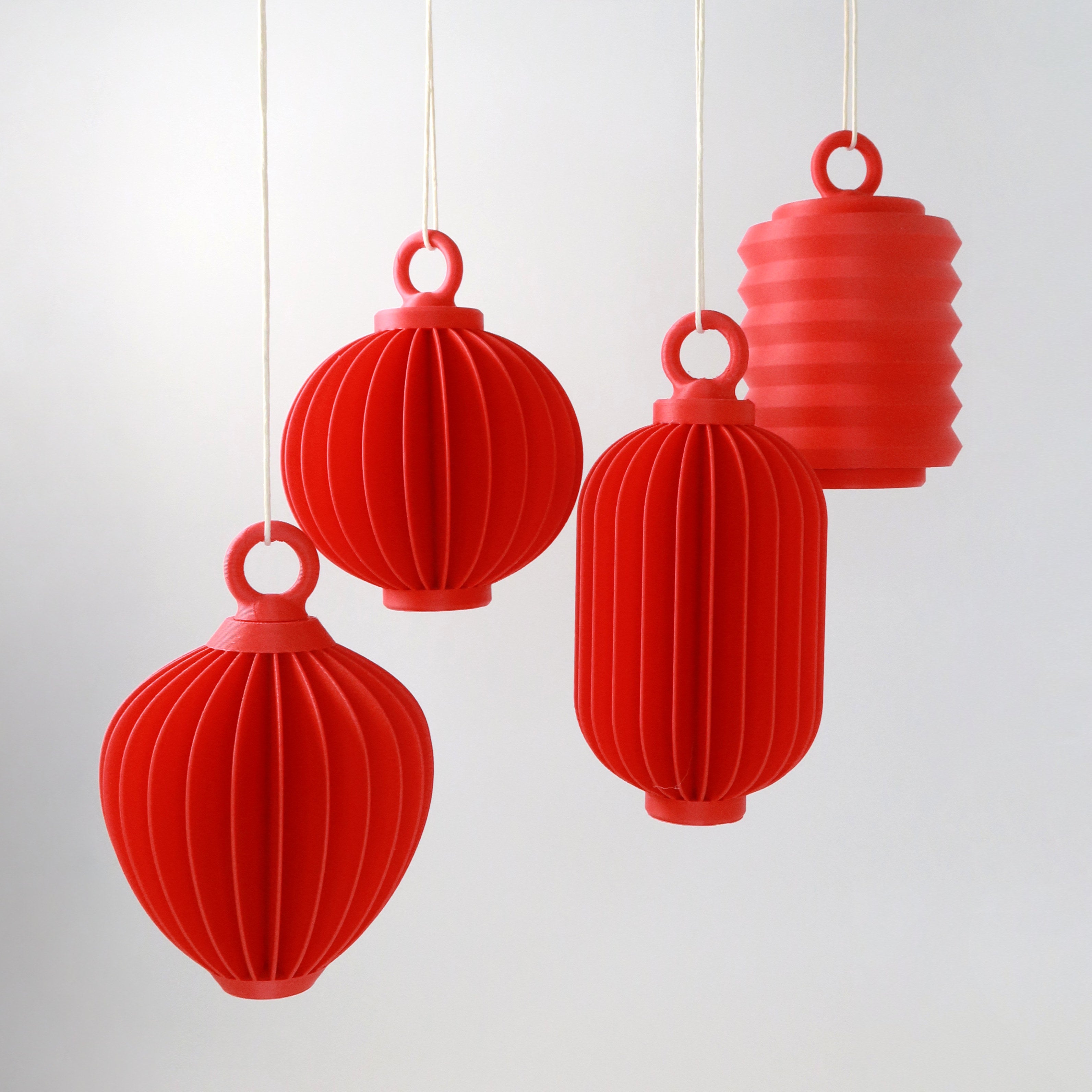 Red lantern-shaped ornaments hanging against a light gray background